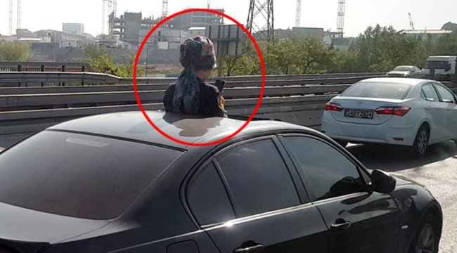 Aracın sunroof'undan çıkan kadın telefonla oynadı